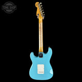 Blue electric guitar with a visible brand logo on a black background