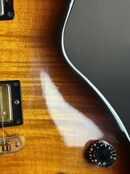 Close-up of a guitar with a focus on the wood grain and hardware.