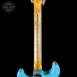 Turquoise electric guitar with a visible brand logo on a black background