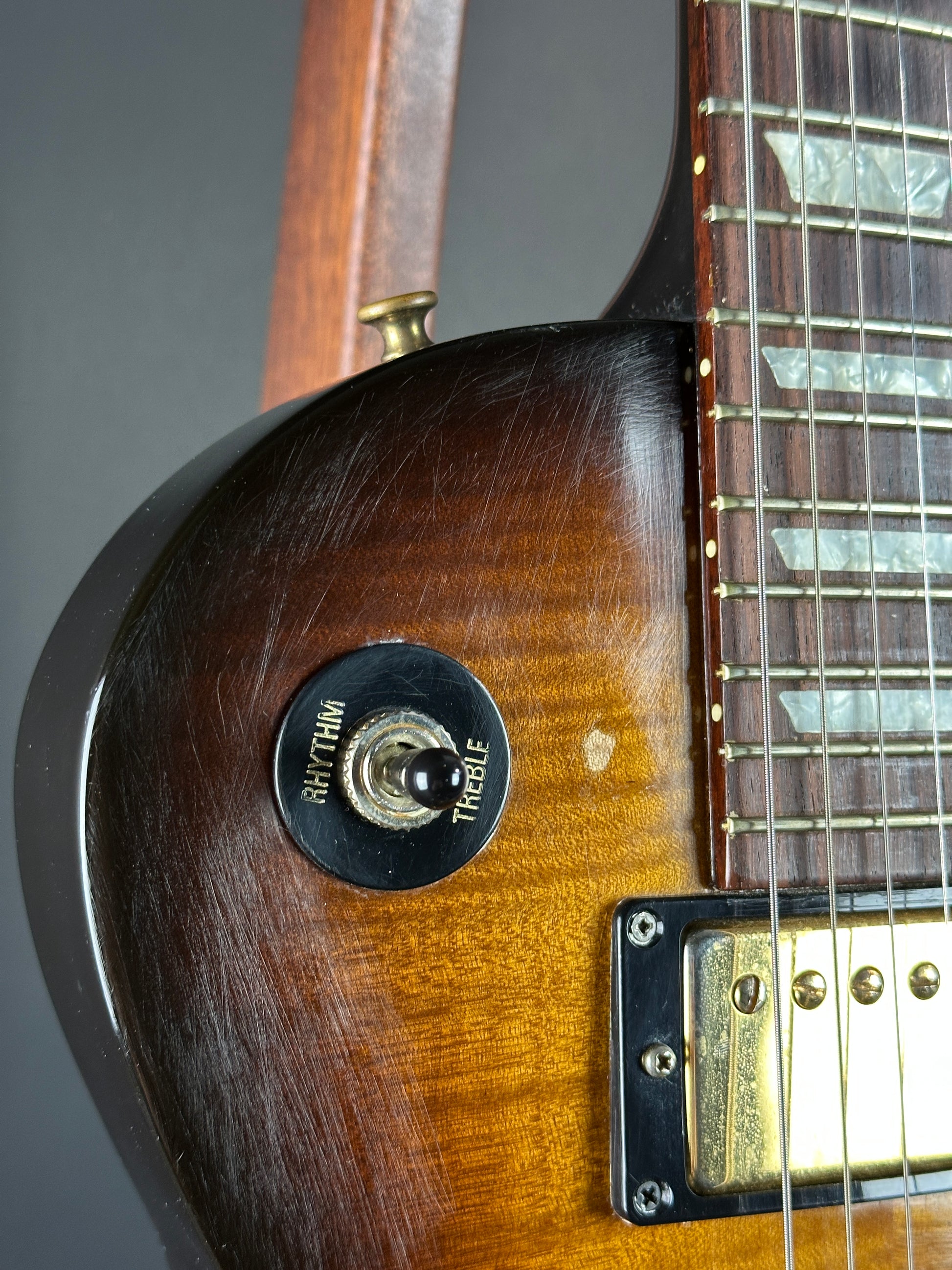 Close-up of a guitar's neck and headstock with a focus on the tuning pegs.
