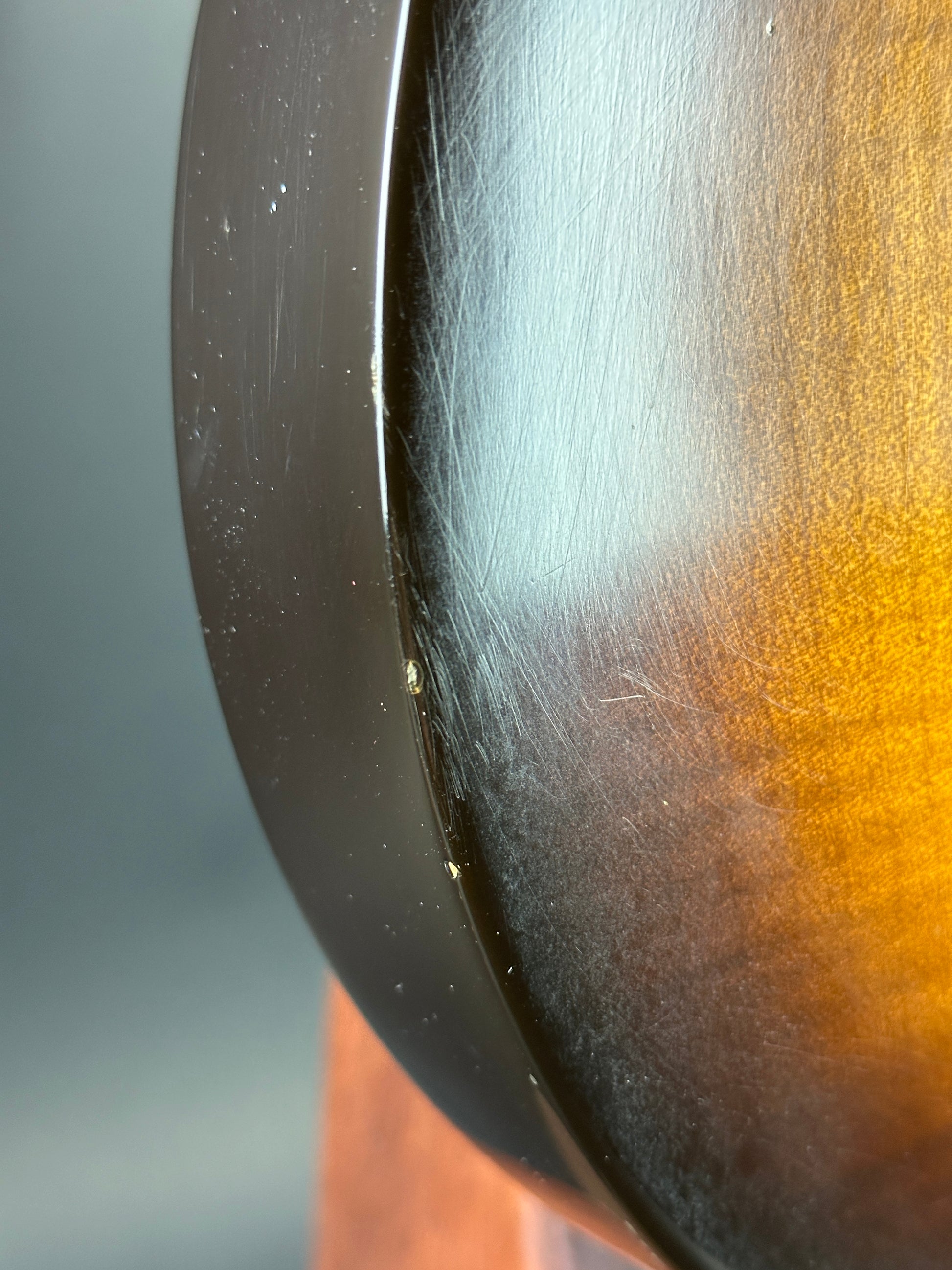 Close-up of a metallic object with a gradient from gold to black.