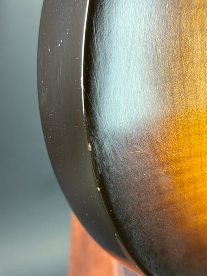 Close-up of a metallic object with a gradient from gold to black.