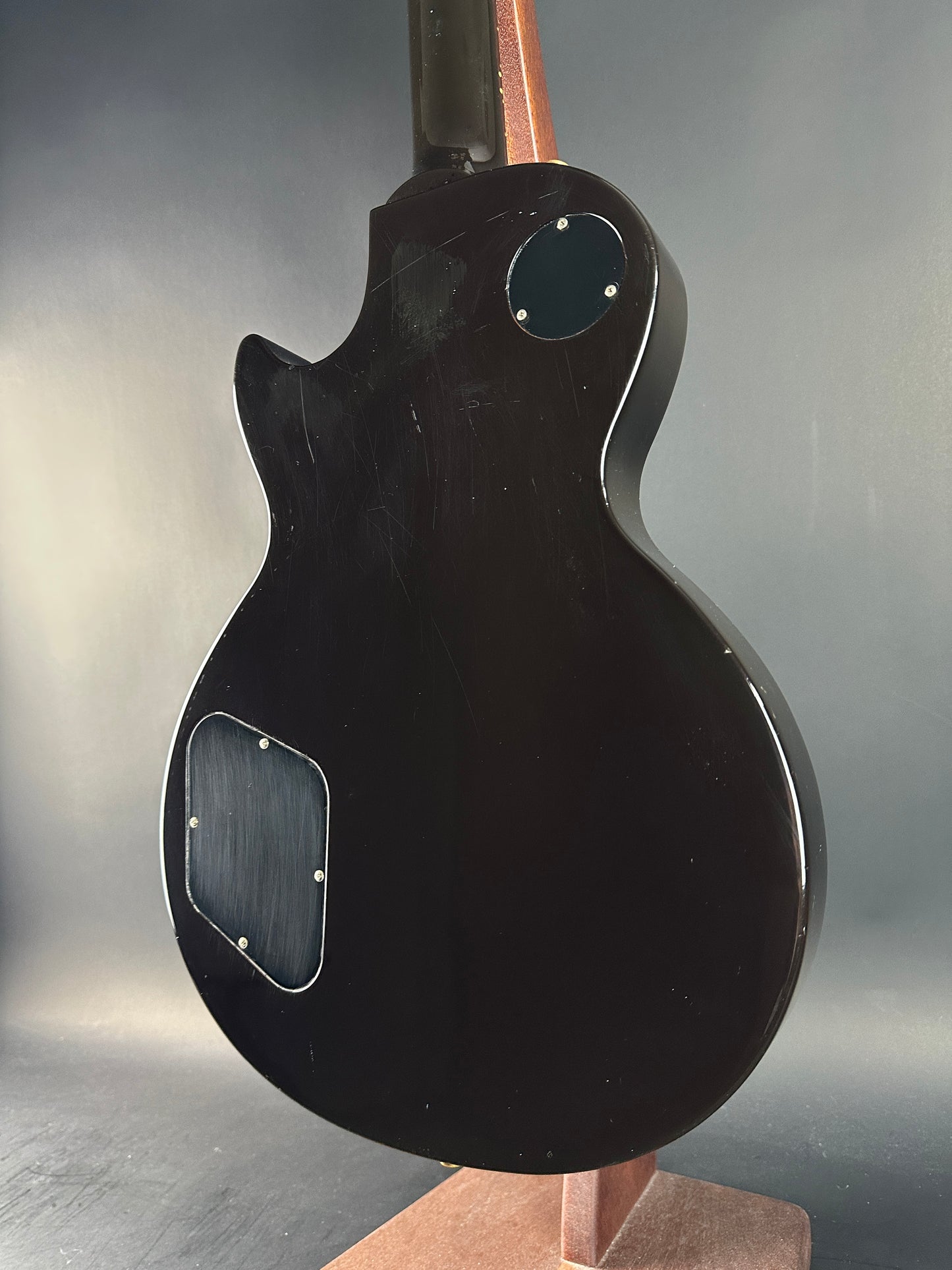 Black electric guitar body on a reflective surface
