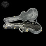 Open guitar case with 'Tone Shop' logo in the corner