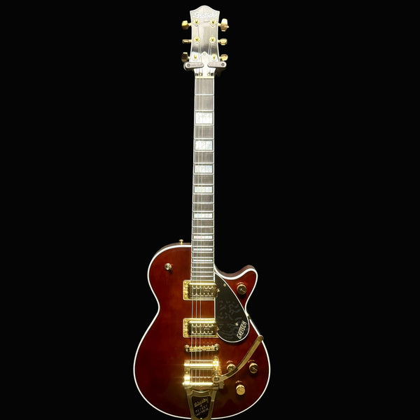 Electric guitar with a sunburst finish against a gray background
