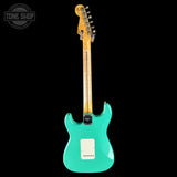 Turquoise electric guitar with a black background