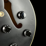 Close-up of a guitar control panel with knobs on a black background