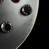 Close-up of a metallic object with three circular components on a black background