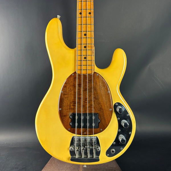 Yellow electric bass guitar on a dark gray background
