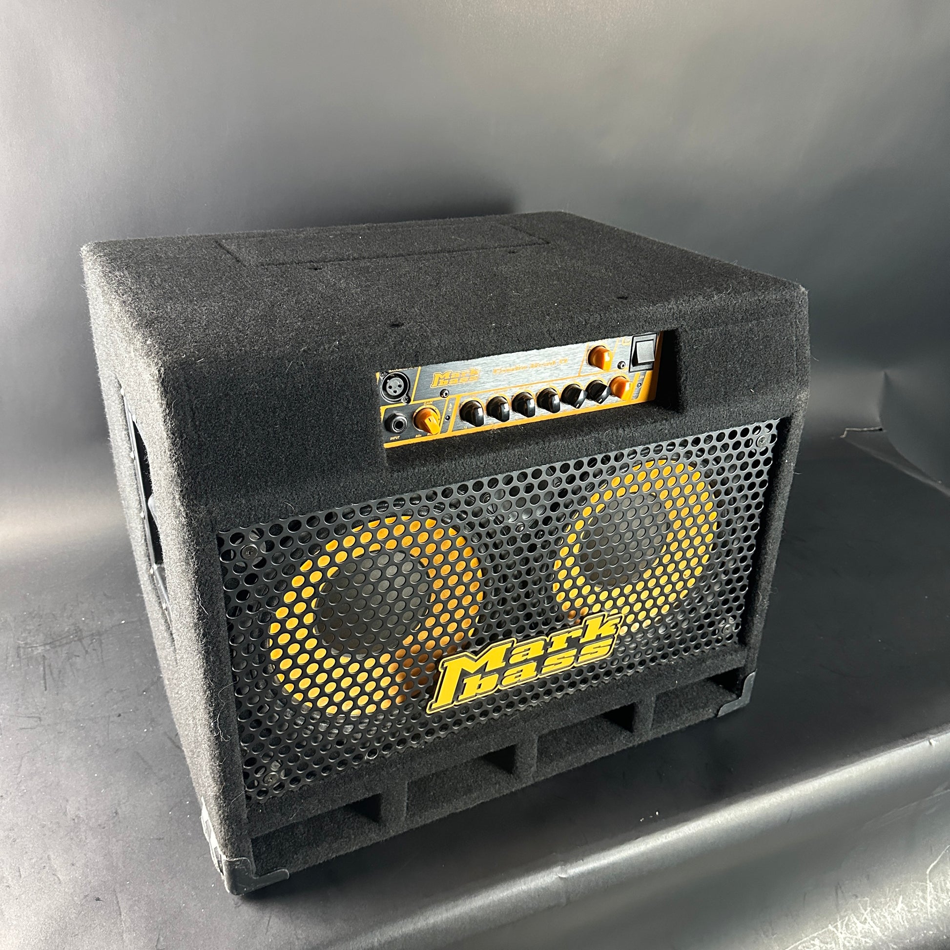 Black guitar amplifier with yellow text on a gray background