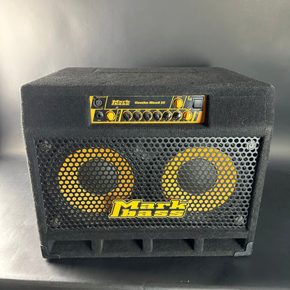 Black guitar amplifier with yellow text and branding on a gray background