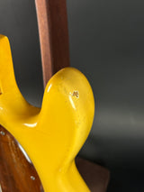 Close-up of a yellow guitar neck with a blurred background