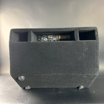 Black speaker enclosure with electronic components on a gray background