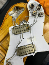 Close-up of a guitar's back with visible wiring and components.