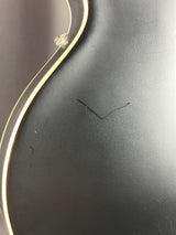 Close-up of a black surface with a small scratch and white border