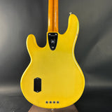 Yellow electric bass guitar on a dark gray background