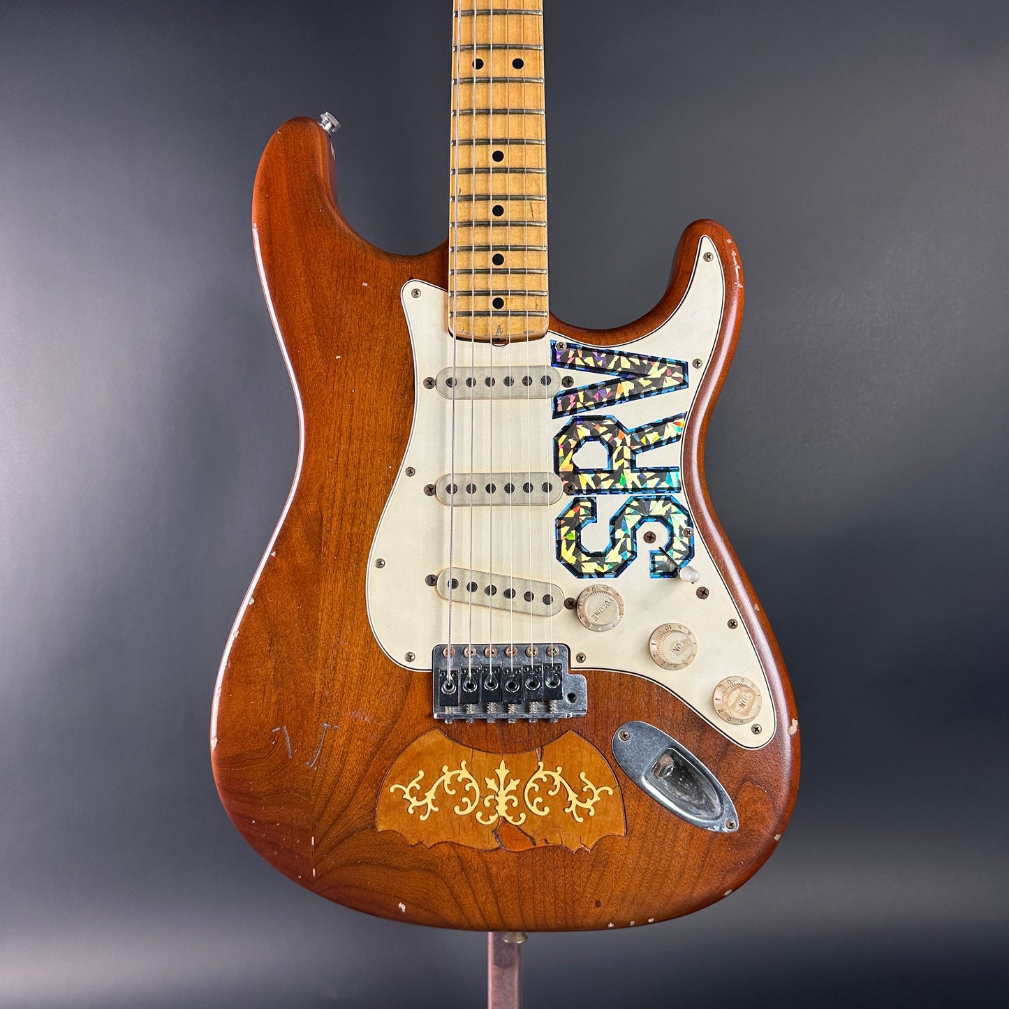 Wooden electric guitar with a unique design on a gray background