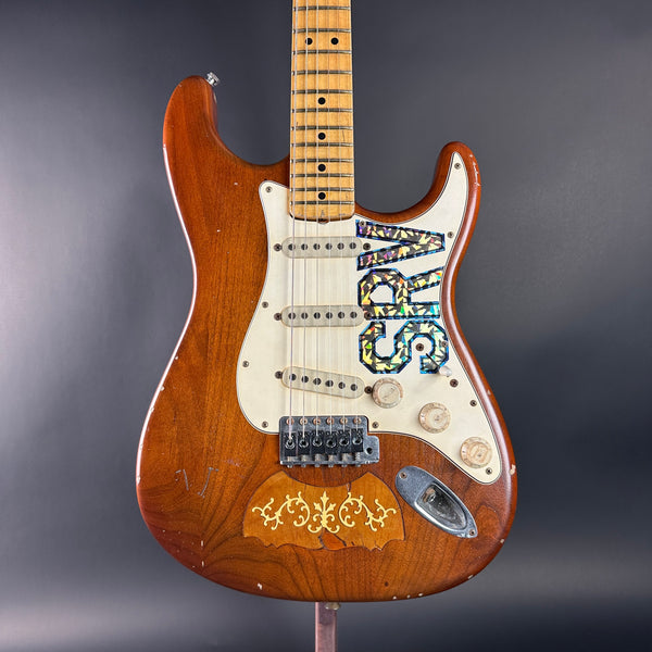 Wooden electric guitar with a unique design on a gray background