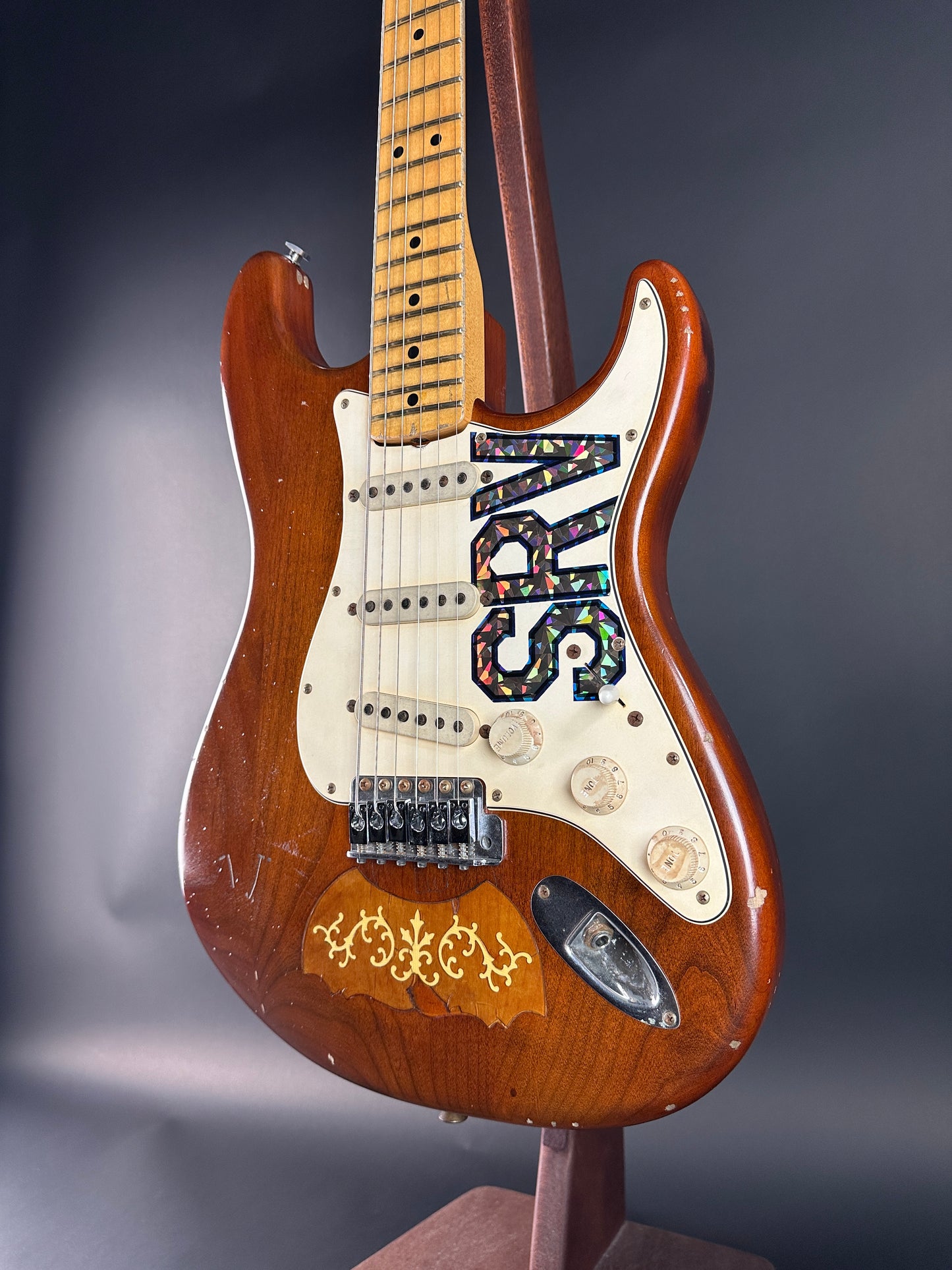 Wooden electric guitar with 'SRY' branding on a dark background