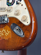 Close-up of a vintage electric guitar with wood finish and control knobs.