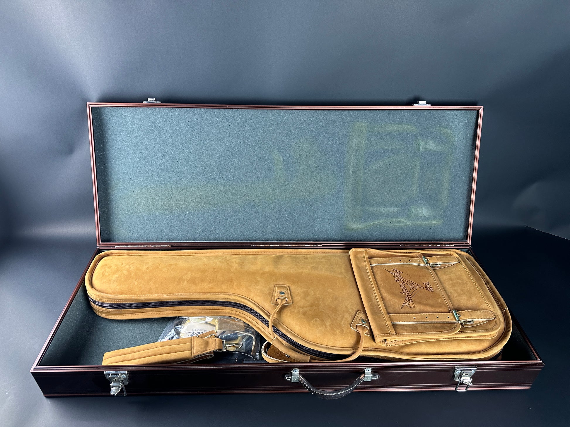 Open guitar case with a blue interior on a dark background