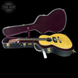 Acoustic guitar in an open case with 'Tone Shop' branding.
