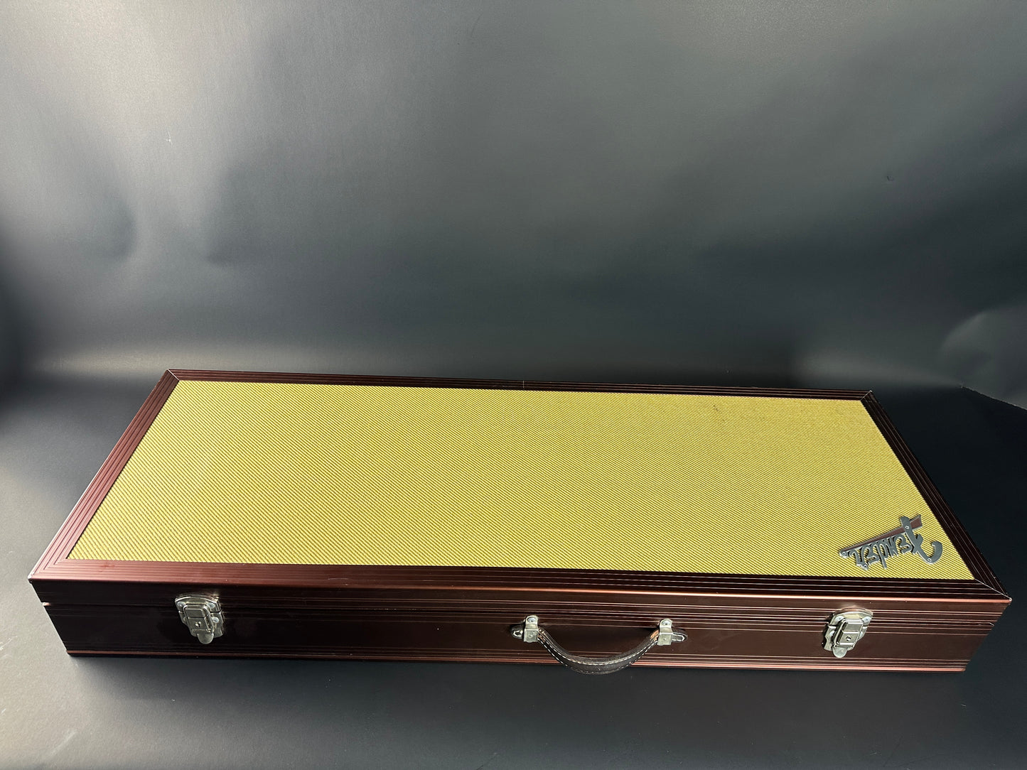Wooden gun case with a yellow interior on a dark background