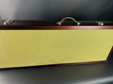 Guitar case with a textured yellow front panel on a dark background