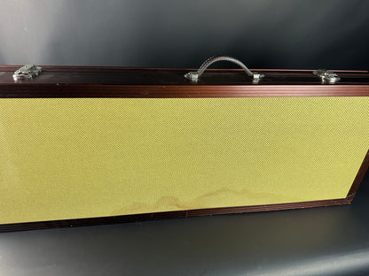 Guitar case with a textured yellow front panel on a dark background