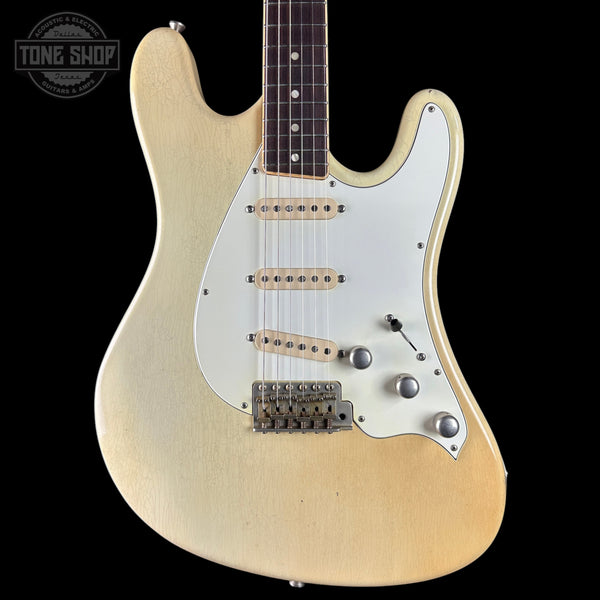 Electric guitar with a blonde finish on a black background, featuring the Tone Shop logo.