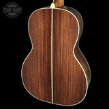 Wooden acoustic guitar body with a visible brand logo in the corner.