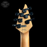 Close-up of the headstock of a guitar against a black background.