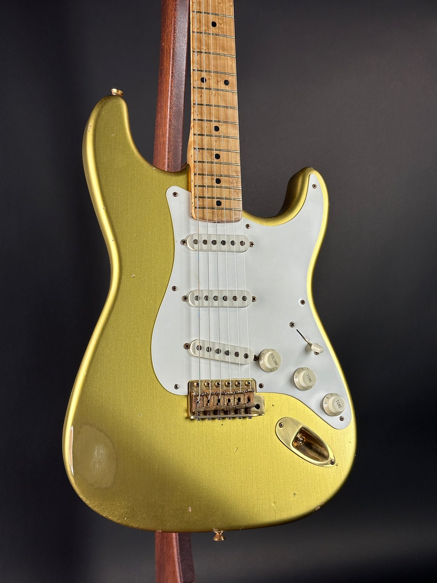 Gold electric guitar with a dark background