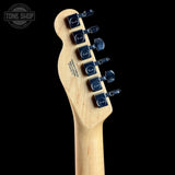 Close-up of the headstock of a Fender electric guitar in natural wood finish with dark blue tuning pegs, shown against a solid black background.