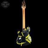 A black electric guitar shown from the back against a solid black background, featuring bright yellow tape-like graphics and a visible Tune Shop watermark in the top-left corner.