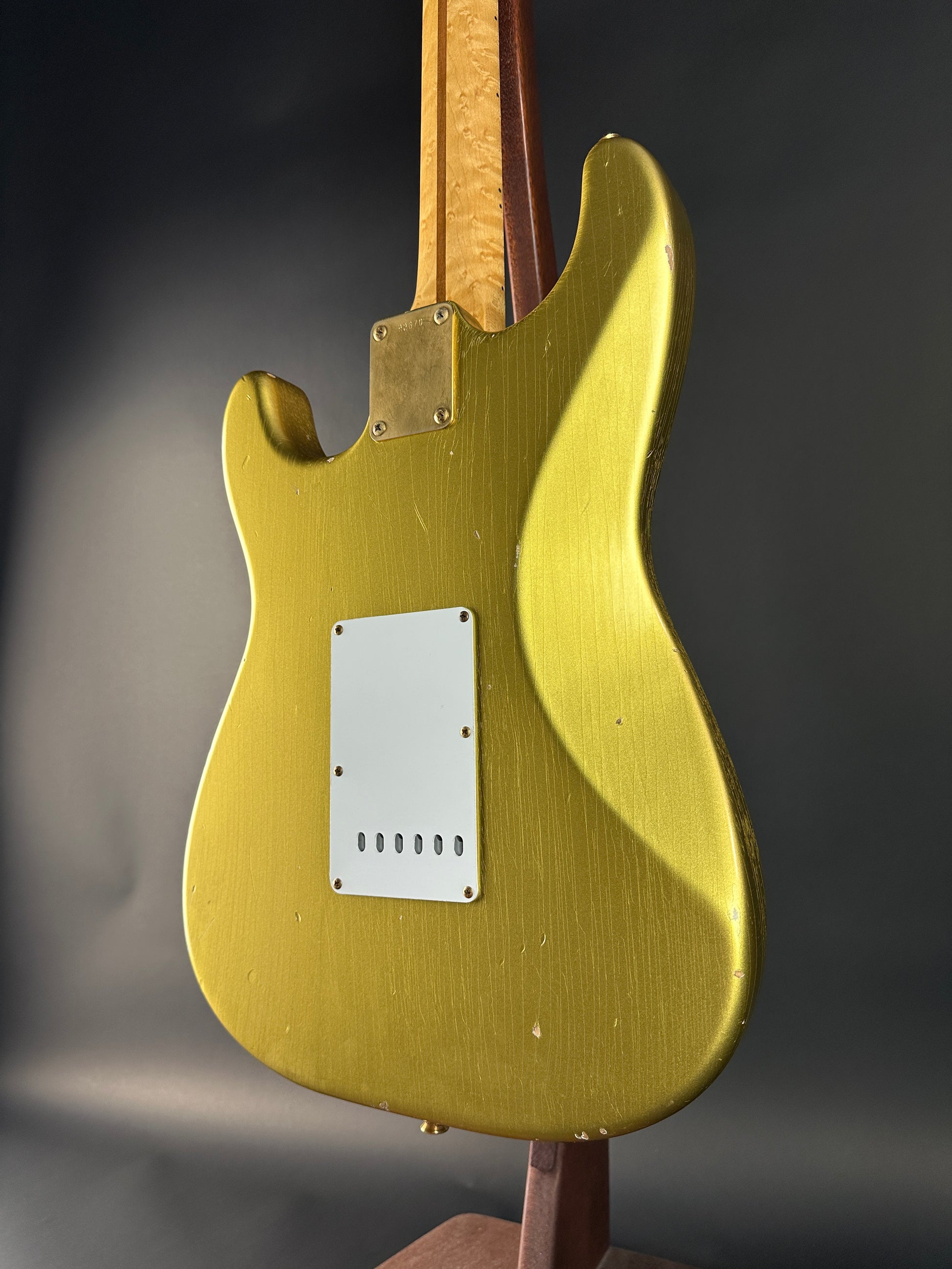 Gold electric guitar body on a dark background