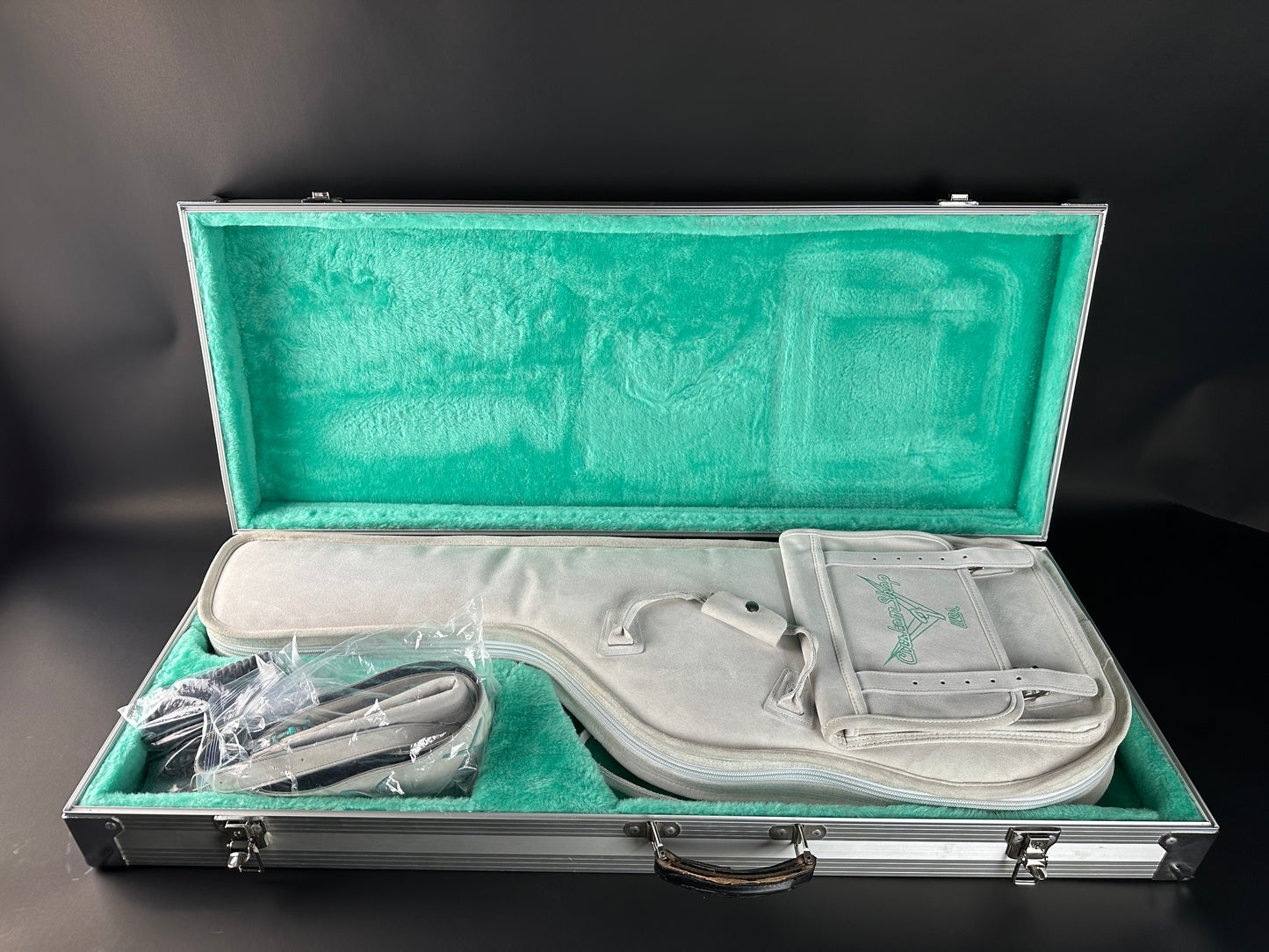 Open guitar case with guitar inside on a dark background