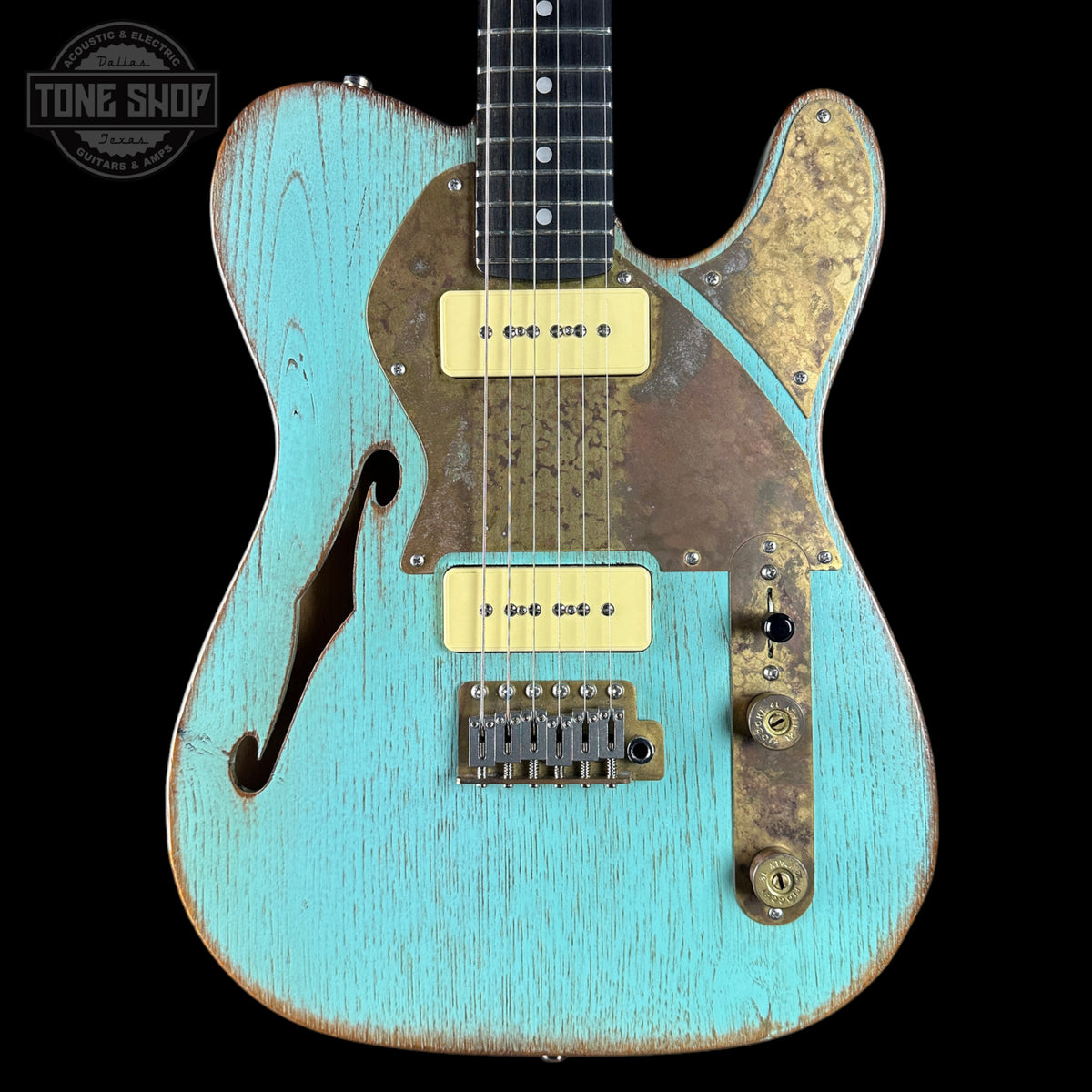 Vintage-style electric guitar with a distressed turquoise finish on a black background.