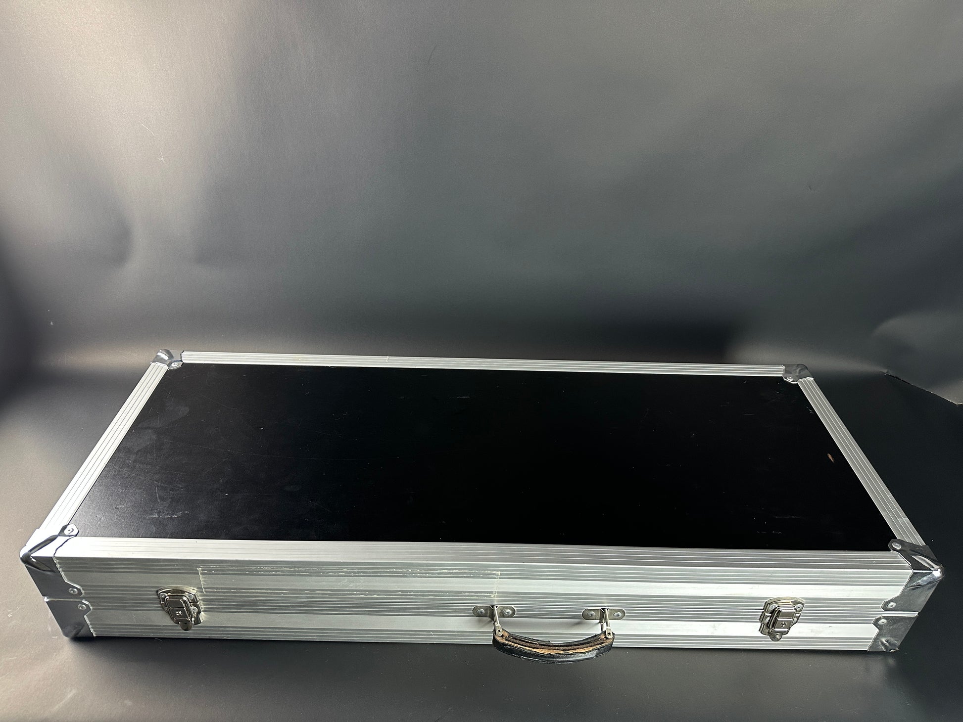 Aluminum briefcase with black interior on a gray background