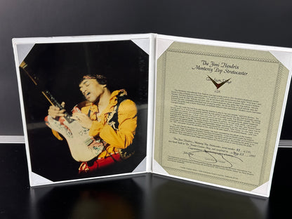 Framed photo of a musician playing guitar with a certificate inside on a dark background