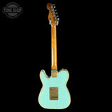 Teal electric guitar with a wooden neck on a black background, featuring 'Tone Shop' logo.