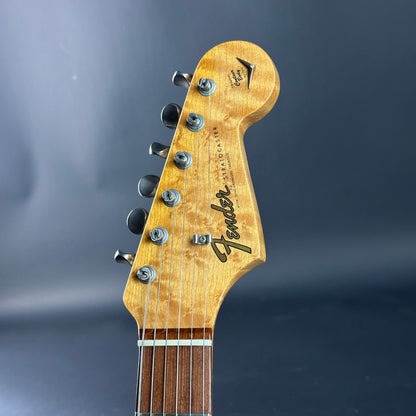 Close-up of a Fender guitar headstock on a dark background