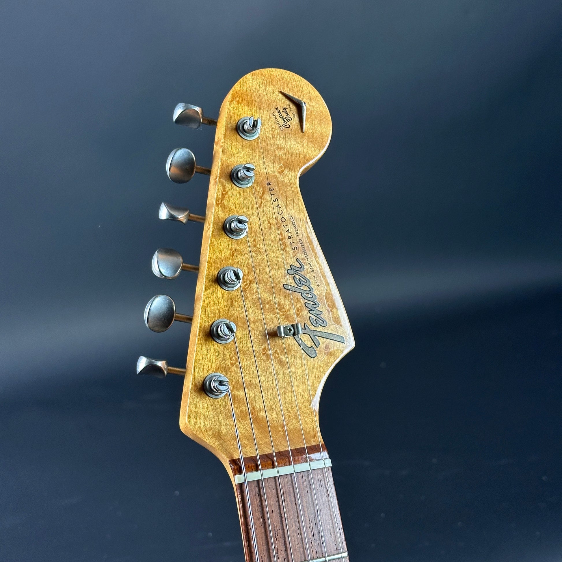 Guitar headstock with Fender logo on a dark background