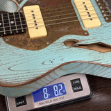 Guitar on a digital scale displaying weight, with a wooden surface in the background