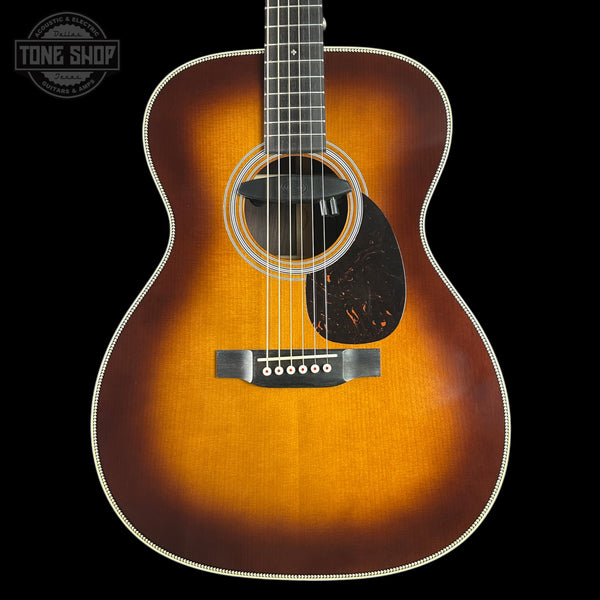 Acoustic guitar with a sunburst finish on a black background, featuring the Tone Shop logo.
