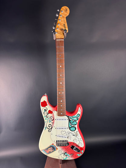 Colorful electric guitar with floral designs on a dark background