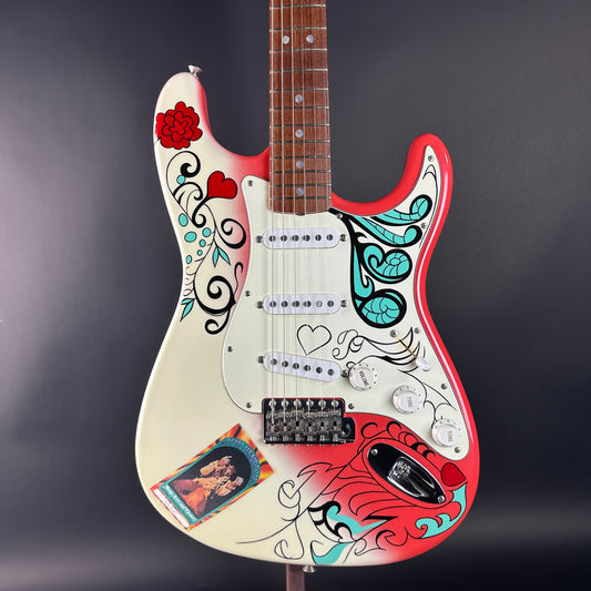 Colorful electric guitar with artistic designs on a dark background