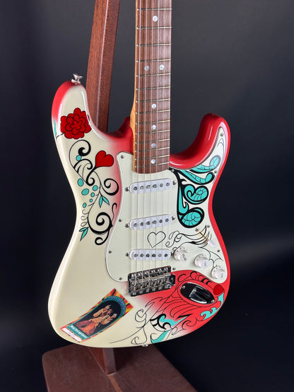 Decorative electric guitar with colorful designs on a black background