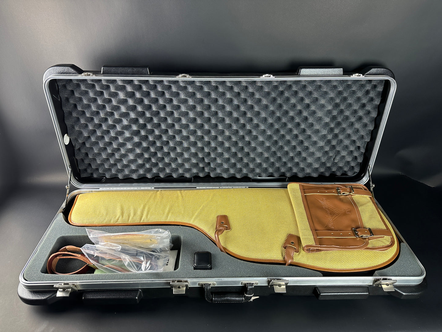 Open protective case with foam lining and items on a gray background