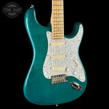 Teal electric guitar with a clear pickguard on a black background, featuring 'Tone Shop' branding.